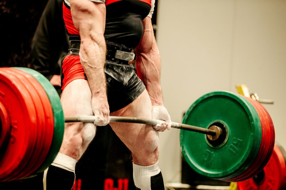 Powerlifter führt auf einer Bühne schweres Kreuzheben aus